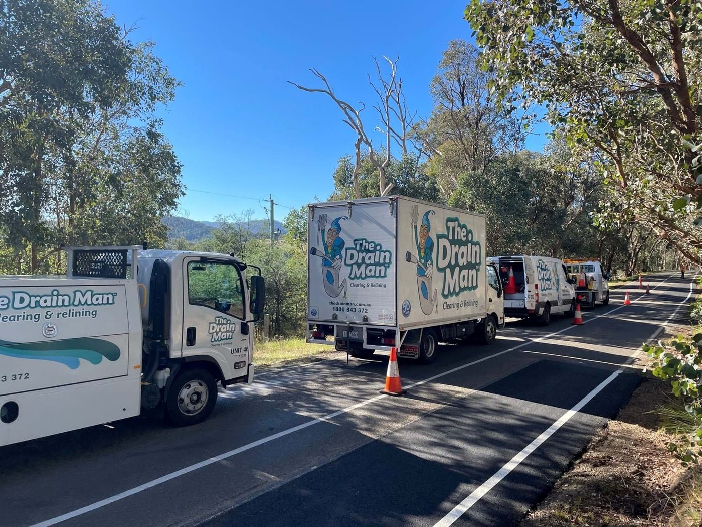 Drain Man trucks and vans lined up on a roadside job